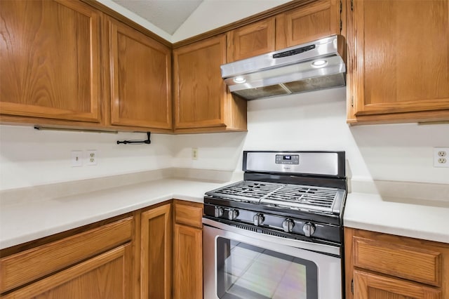 10306 Wayward Wind Ln, Houston, TX 77064 - kitchen with stainless steel range with gas cooktop, range hood, light countertops, and brown cabinets