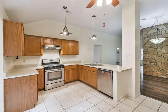 kitchen featuring kitchen peninsula, appliances with stainless steel finishes, sink, light hardwood / wood-style flooring, and hanging light fixtures