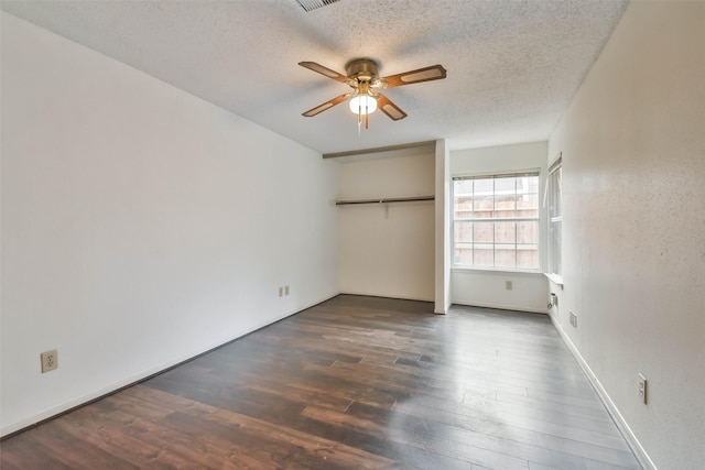 unfurnished bedroom with a textured ceiling, dark hardwood / wood-style floors, and ceiling fan