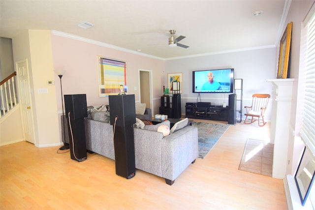 living room featuring light hardwood / wood-style floors, ceiling fan, and crown molding