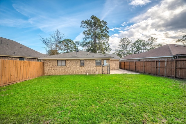 rear view of house featuring a patio area and a yard