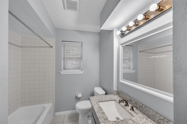 full bathroom featuring tile patterned floors, vanity, tiled shower / bath, and toilet