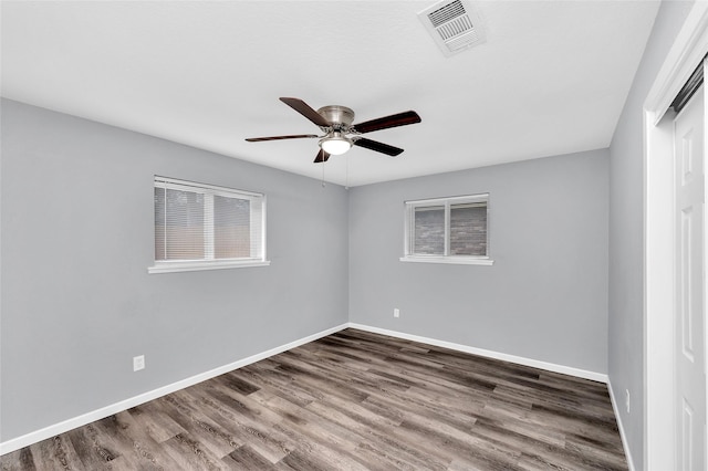 spare room with dark hardwood / wood-style flooring and ceiling fan