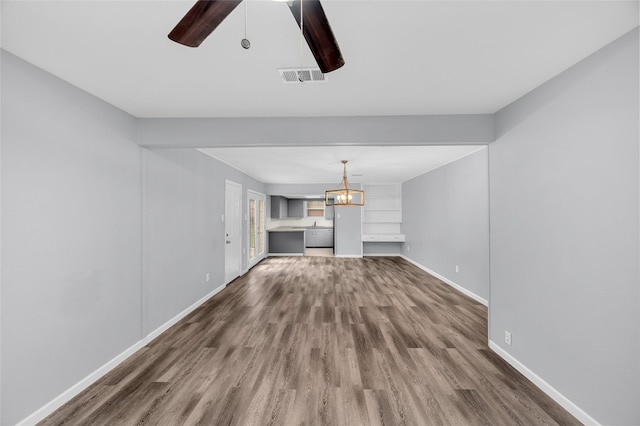 unfurnished living room featuring hardwood / wood-style floors and ceiling fan with notable chandelier