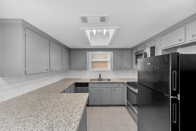 kitchen featuring appliances with stainless steel finishes, gray cabinets, light tile patterned floors, and sink