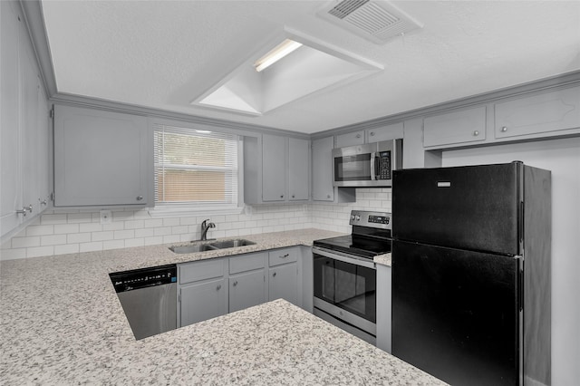 kitchen with decorative backsplash, a textured ceiling, stainless steel appliances, sink, and gray cabinets