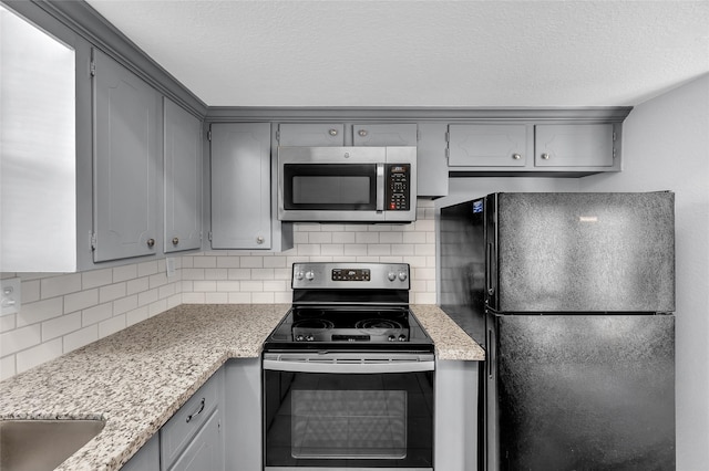 kitchen featuring gray cabinetry, appliances with stainless steel finishes, and tasteful backsplash