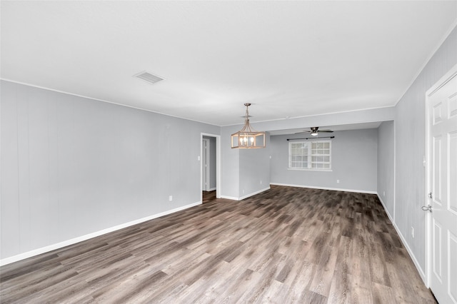 empty room with hardwood / wood-style floors, ceiling fan with notable chandelier, and crown molding