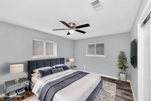 bedroom with dark hardwood / wood-style floors and ceiling fan