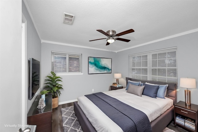 bedroom with a textured ceiling, ceiling fan, crown molding, and dark hardwood / wood-style floors