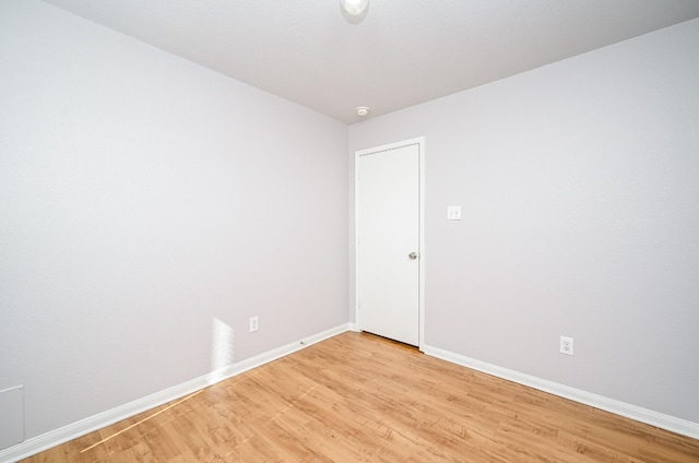 spare room featuring light wood-type flooring and baseboards