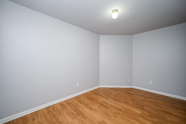 spare room featuring light wood-type flooring and baseboards