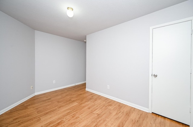 empty room with baseboards and light wood-style floors