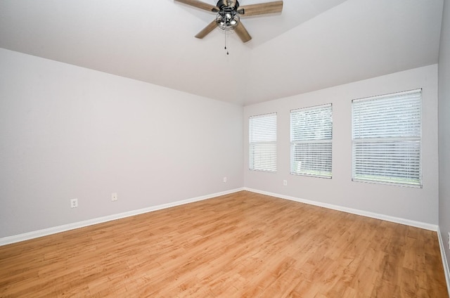 empty room featuring light wood finished floors, ceiling fan, baseboards, and vaulted ceiling