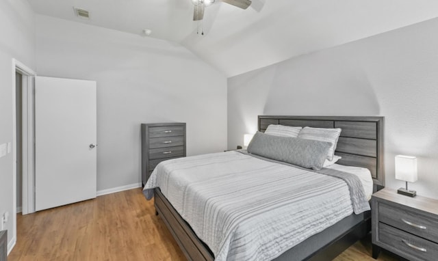 bedroom featuring lofted ceiling, visible vents, light wood-style floors, ceiling fan, and baseboards