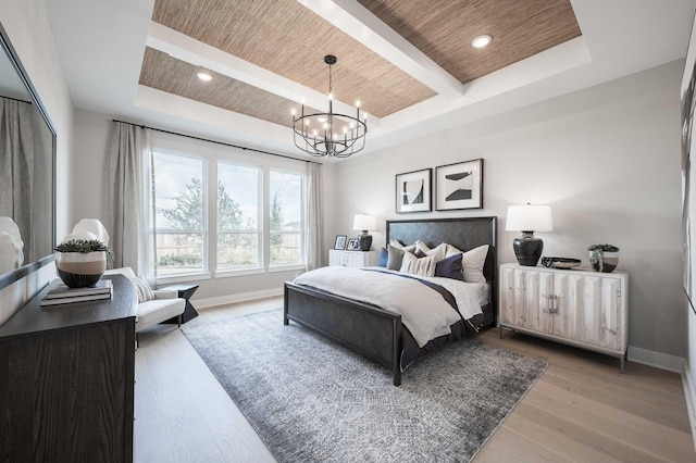 bedroom with wood ceiling, wood-type flooring, a tray ceiling, and an inviting chandelier