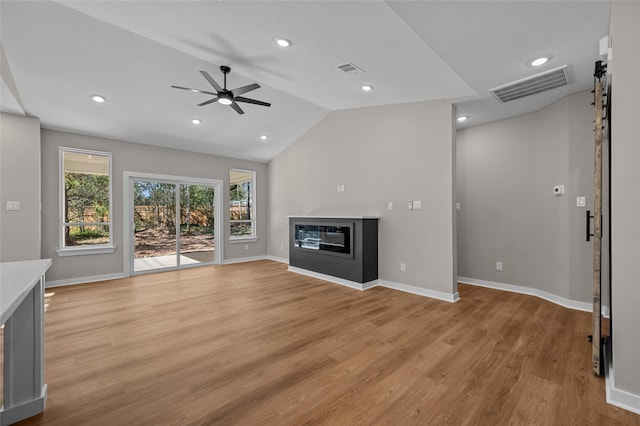 unfurnished living room featuring light hardwood / wood-style flooring, vaulted ceiling, and ceiling fan