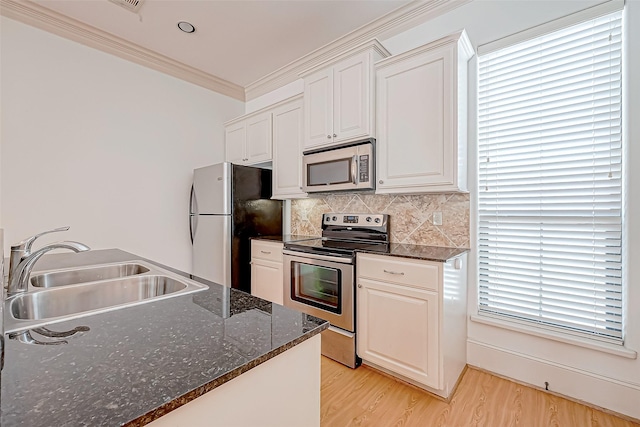 kitchen with sink, white cabinets, dark stone counters, and appliances with stainless steel finishes