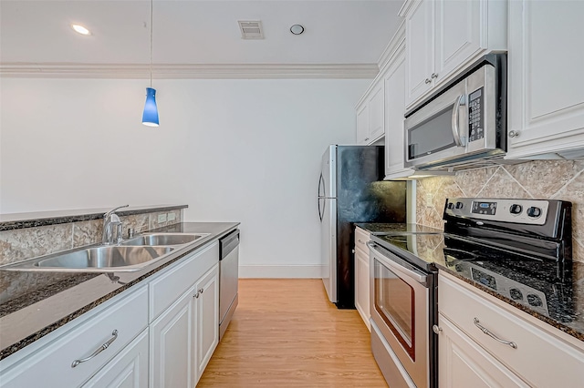 kitchen featuring white cabinetry, pendant lighting, stainless steel appliances, and sink