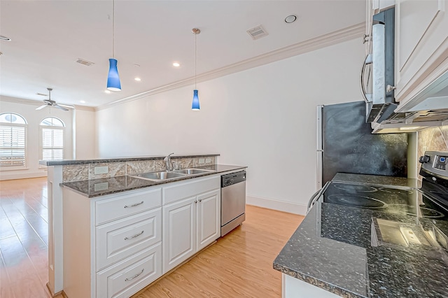 kitchen with white cabinetry, sink, light hardwood / wood-style floors, decorative light fixtures, and appliances with stainless steel finishes