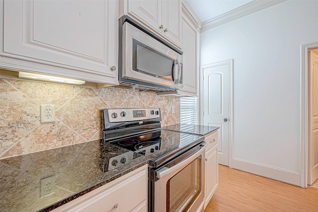 kitchen featuring white cabinetry, backsplash, appliances with stainless steel finishes, and light hardwood / wood-style flooring