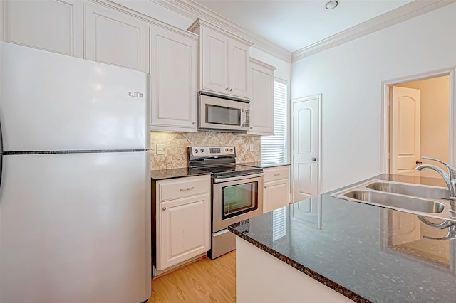 kitchen with crown molding, sink, white cabinets, and appliances with stainless steel finishes