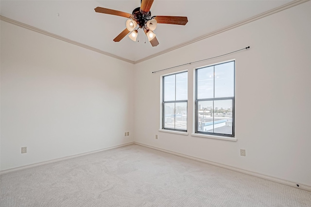 empty room featuring ceiling fan, crown molding, and carpet floors