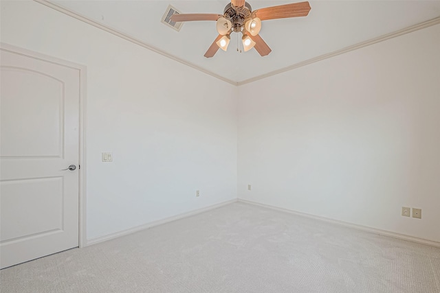 spare room featuring ceiling fan, crown molding, and light colored carpet