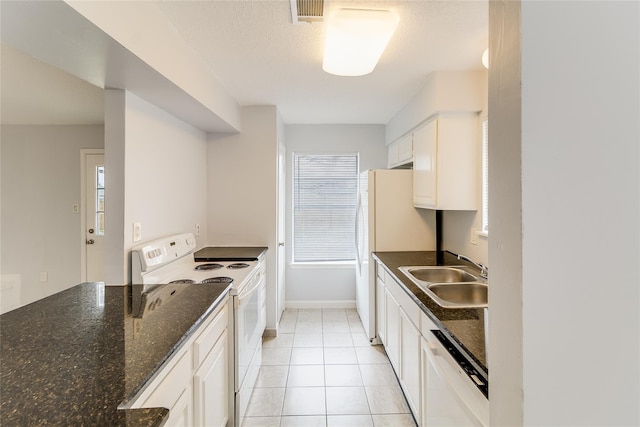 kitchen featuring white appliances, white cabinets, sink, dark stone countertops, and light tile patterned flooring