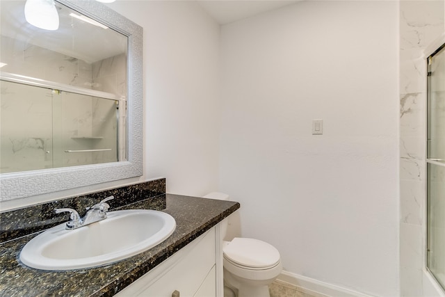 bathroom with tile patterned floors, a shower with door, vanity, and toilet