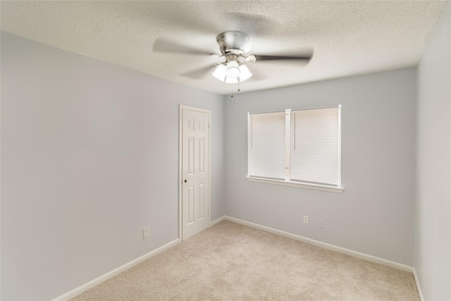 carpeted empty room featuring a textured ceiling and ceiling fan