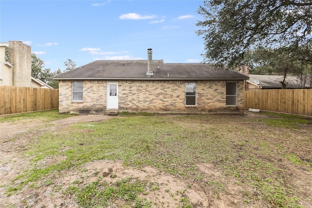 rear view of house featuring a yard