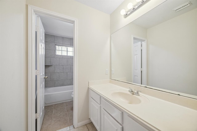 full bathroom with tile patterned flooring, vanity, tiled shower / bath combo, and toilet