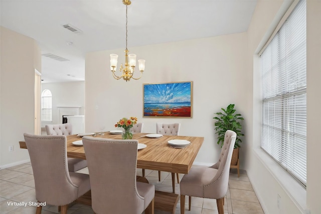 tiled dining room with a notable chandelier