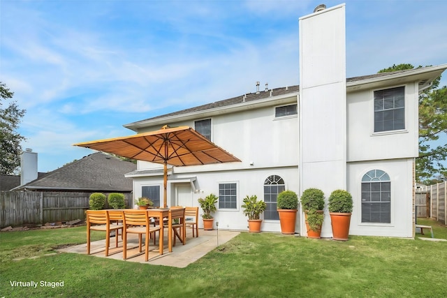 rear view of property featuring a yard and a patio