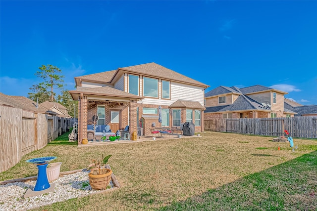 rear view of house with a lawn and a patio