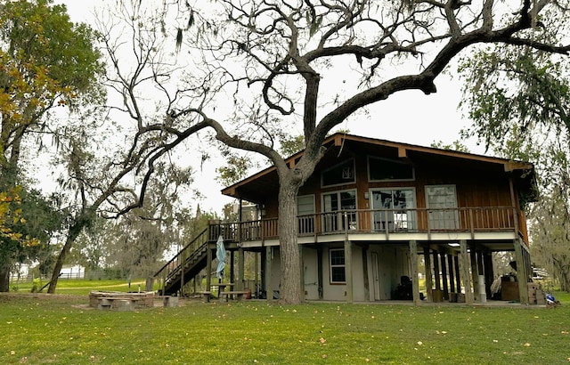 rear view of house with a yard and a wooden deck