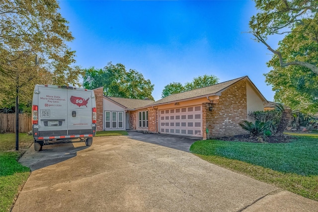 single story home with a garage and a front lawn