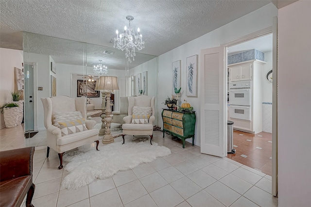 sitting room featuring a chandelier, a textured ceiling, and light tile patterned flooring