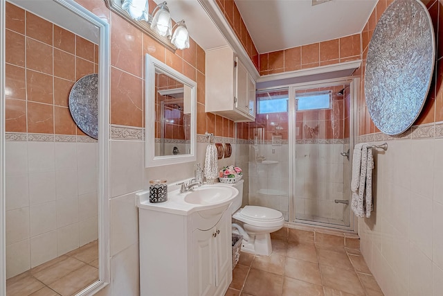 bathroom featuring tile patterned flooring, vanity, tile walls, and toilet