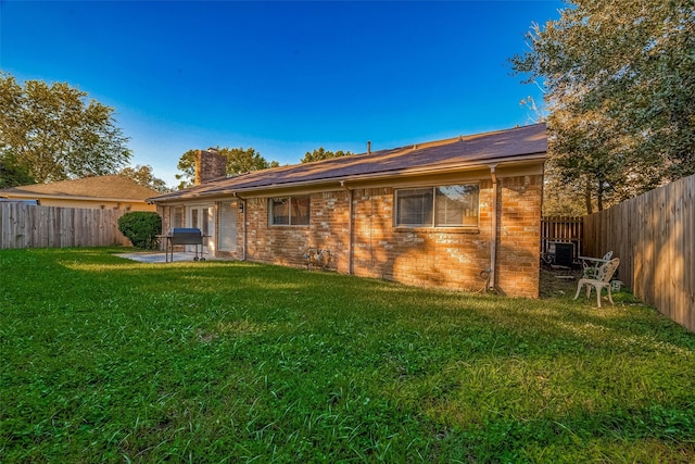 rear view of property featuring a patio area and a yard