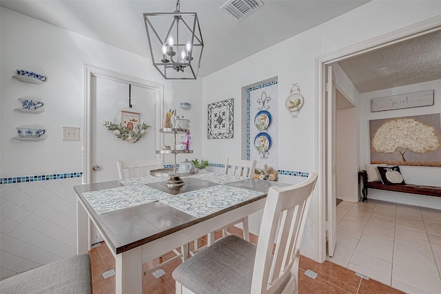 dining space featuring a notable chandelier and light tile patterned floors