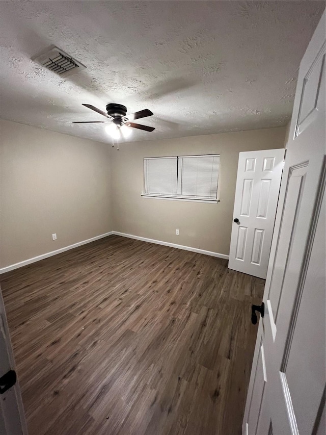 unfurnished room with dark hardwood / wood-style floors and a textured ceiling