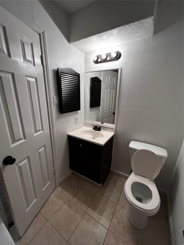 bathroom with tile patterned floors, vanity, and toilet