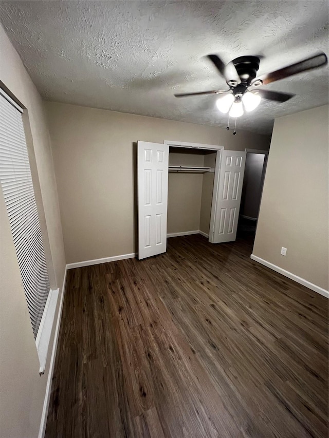 unfurnished bedroom featuring dark hardwood / wood-style flooring, a textured ceiling, a closet, and ceiling fan