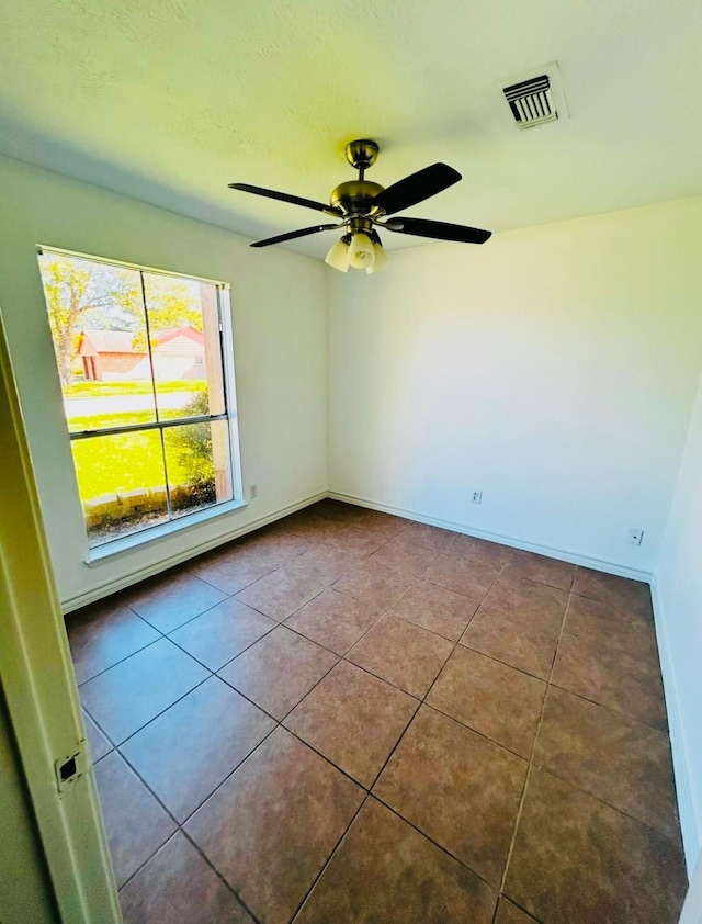 tiled empty room with ceiling fan