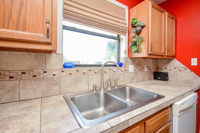 kitchen with tasteful backsplash, dishwasher, sink, and tile counters