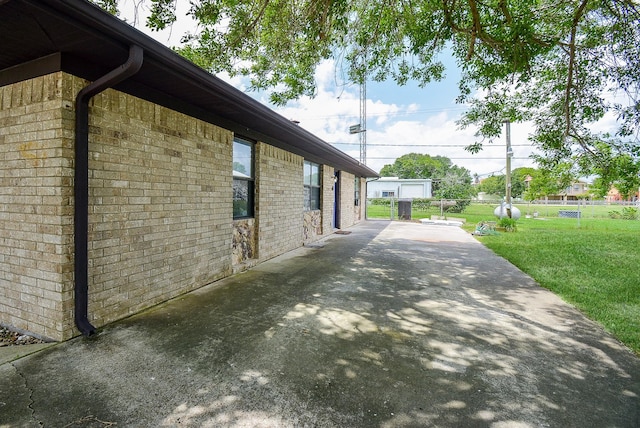 view of side of home with a yard and a patio