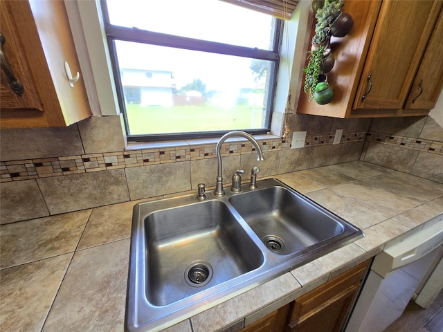1495 W Bayshore Dr, Palacios, TX 77465 - kitchen with a sink, brown cabinetry, tile counters, and decorative backsplash