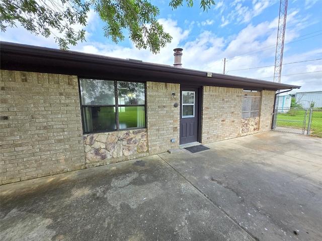 1495 W Bayshore Dr, Palacios, TX 77465 - rear view of property with a patio area, fence, and brick siding